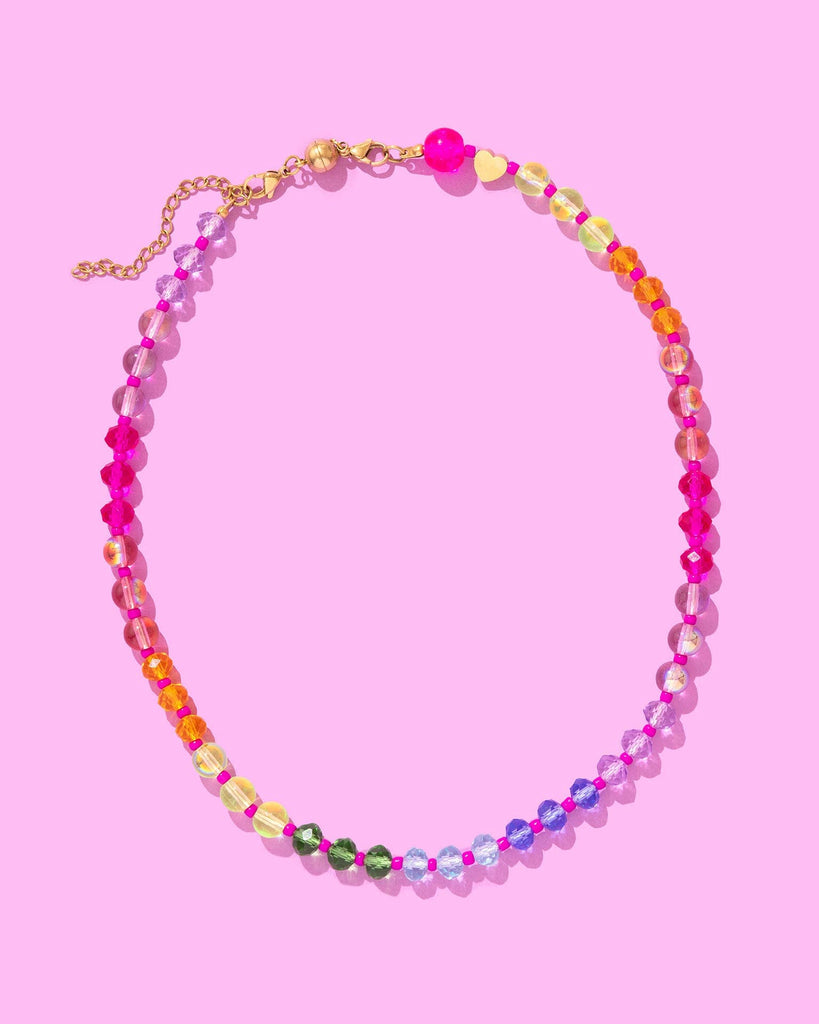 Colorful beaded necklace on a pink background