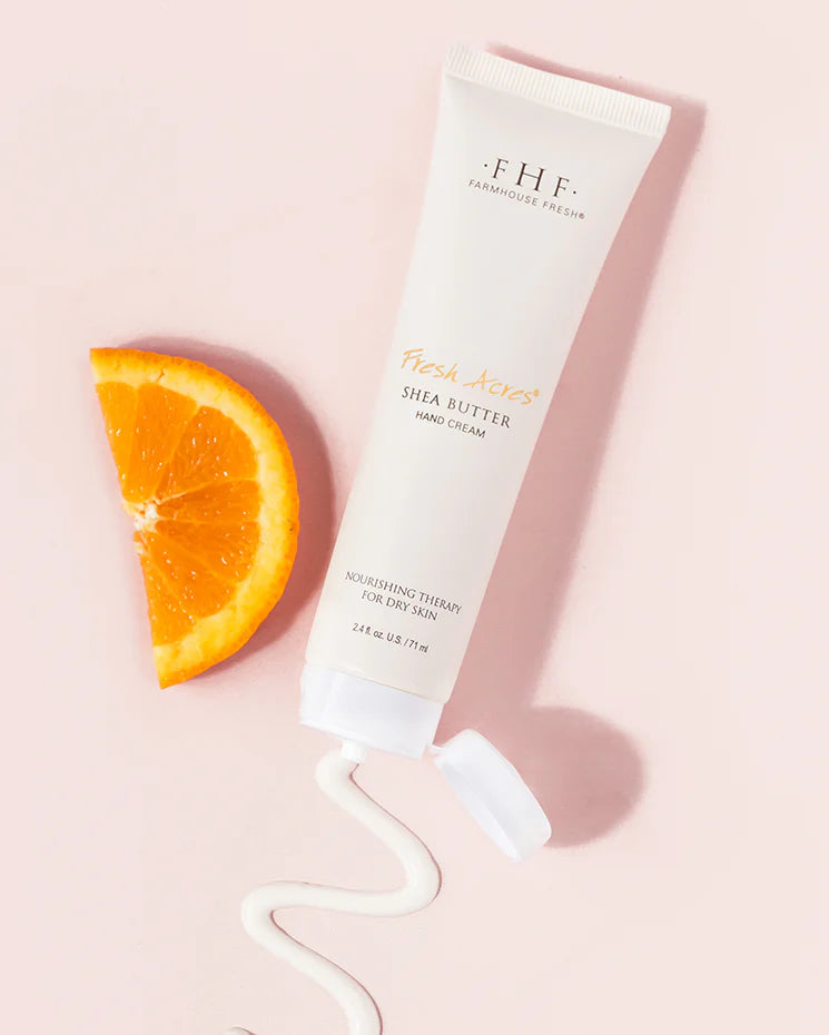 Tube of FHF cream with an orange slice on a pink background