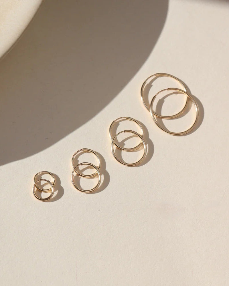 Set of gold rings on a beige surface with soft shadows