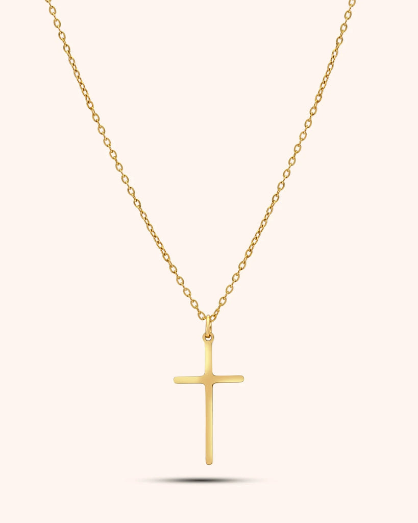 Gold cross necklace on a white background