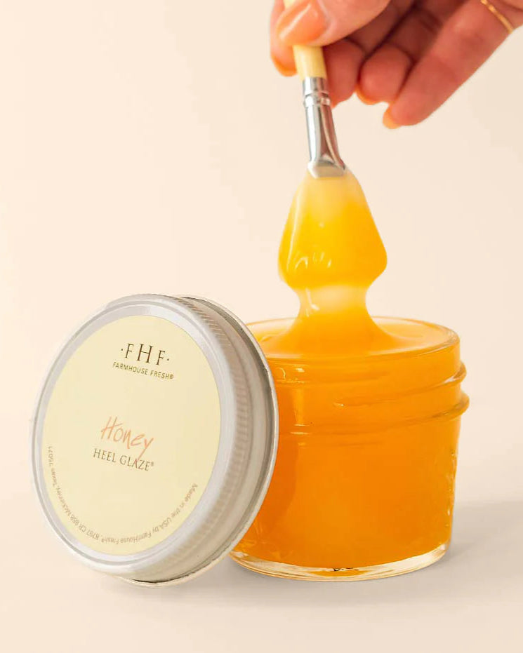 Jar of honey with a spoonful being lifted, branded 'FHF'.