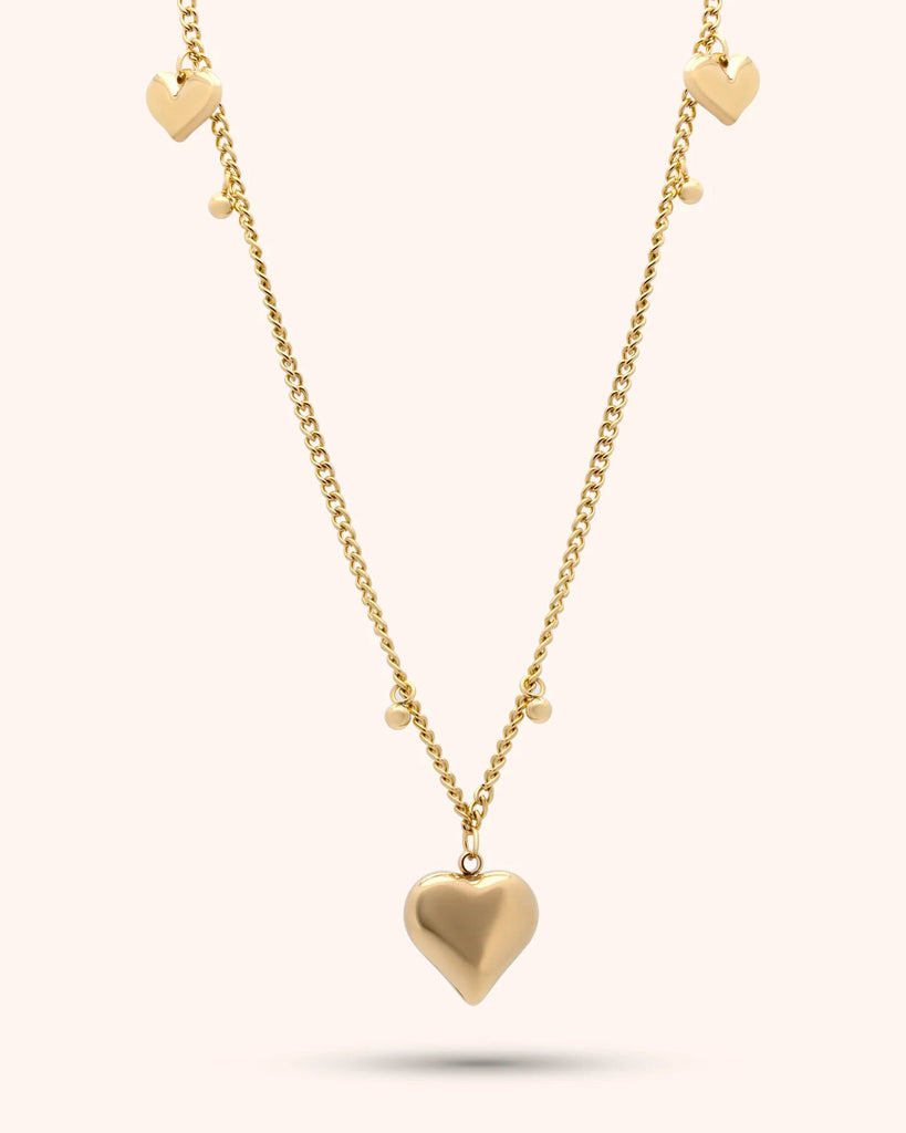Gold heart-shaped necklace on a white background