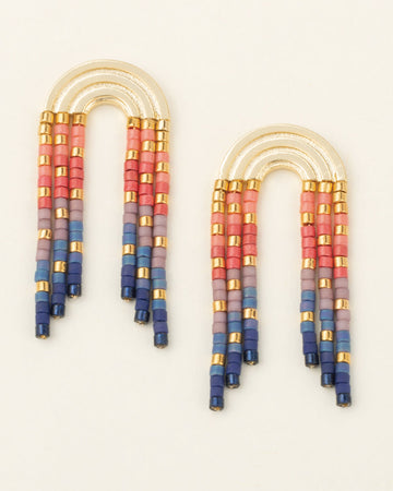 Colorful beaded earrings on a light beige background