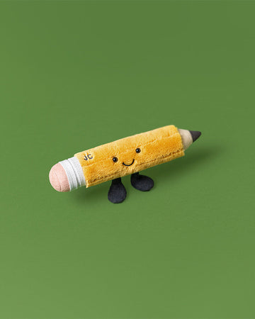 Plush toy pencil with a smiling face on a green background