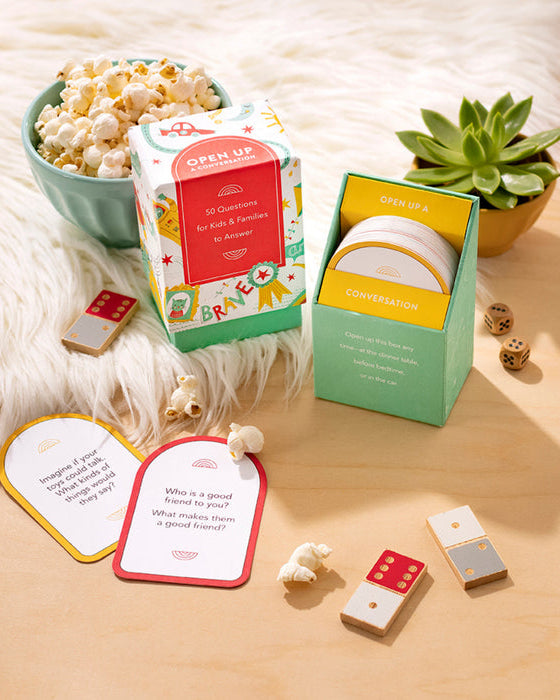Conversation starter cards with dice and popcorn on a soft surface