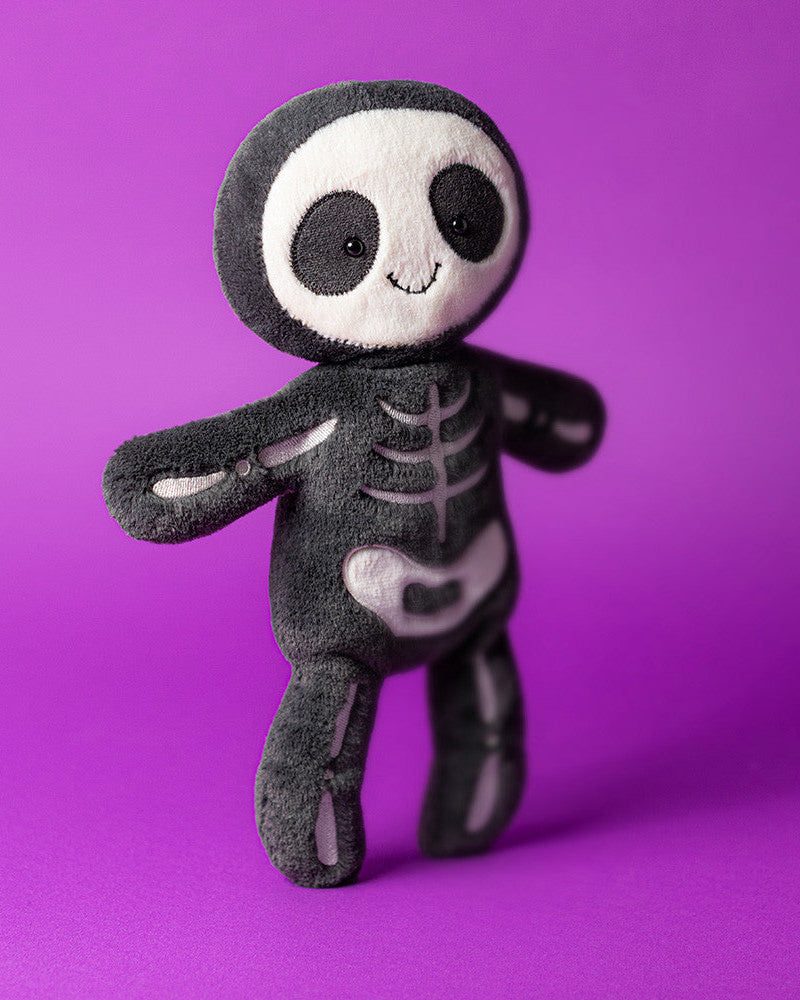 Skeleton plush toy on a purple background