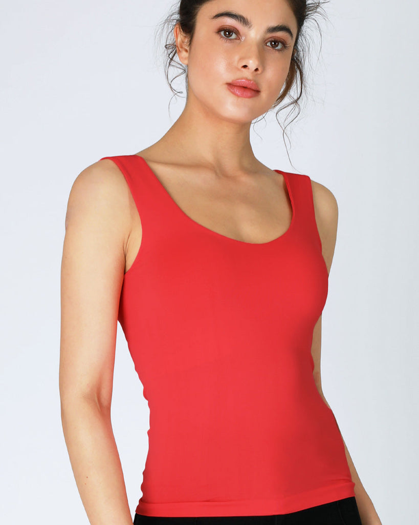 Woman wearing a red tank top against a white background